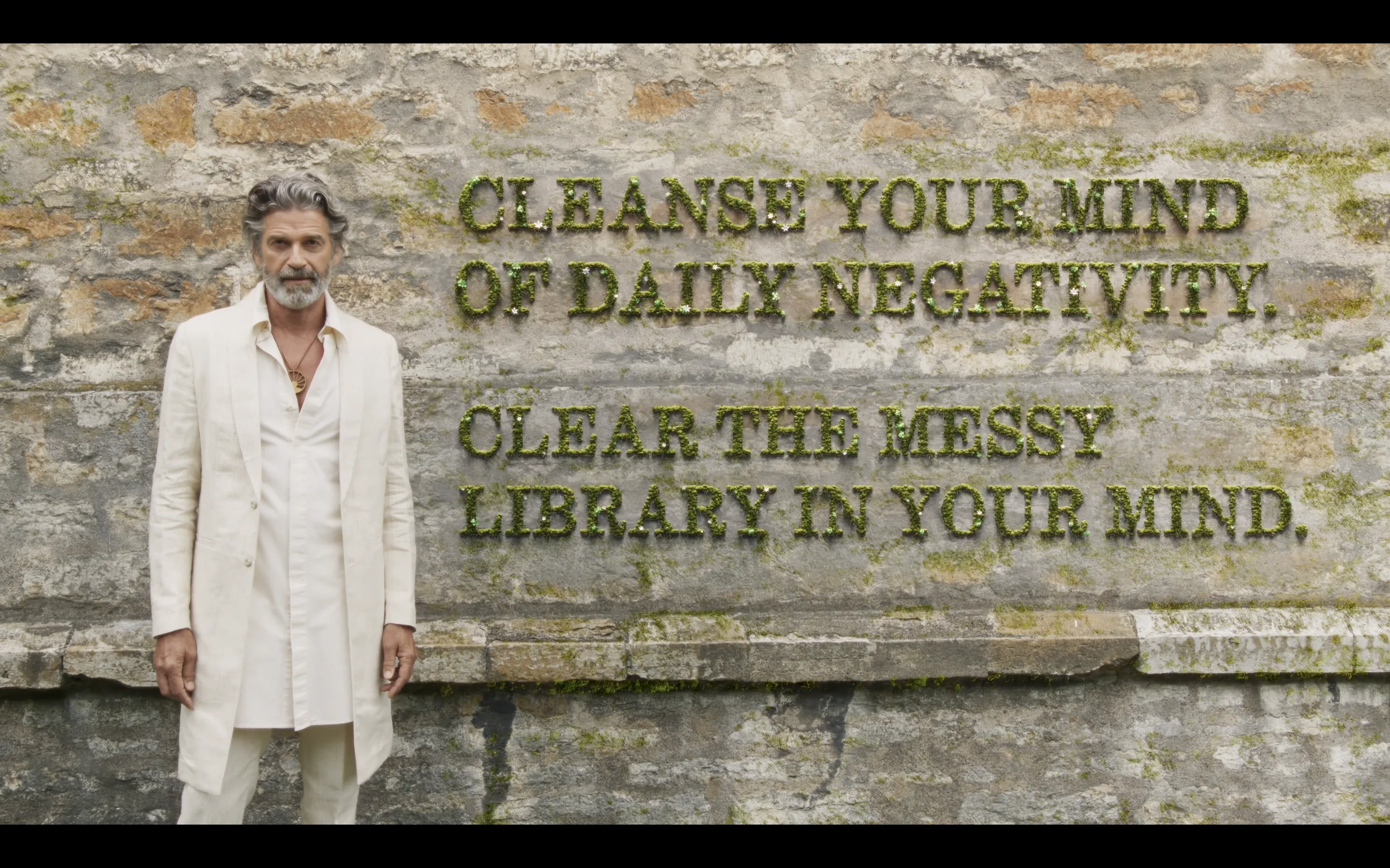 Platon Tinn standing beside a stone wall — Cleanse your mind of daily negativity. Clear the messy library in your mind.